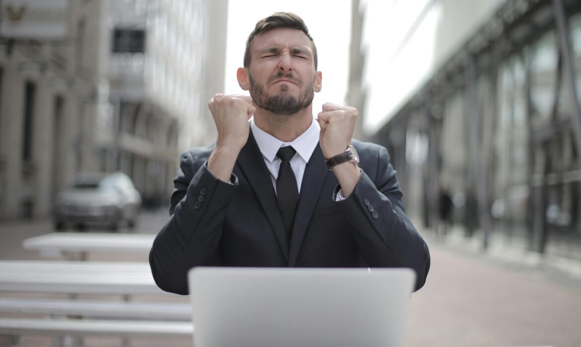 Imagem de um homem de terno atrás de um notebook com uma expressão frustrada por perceber que teve a proteção de dados em risco